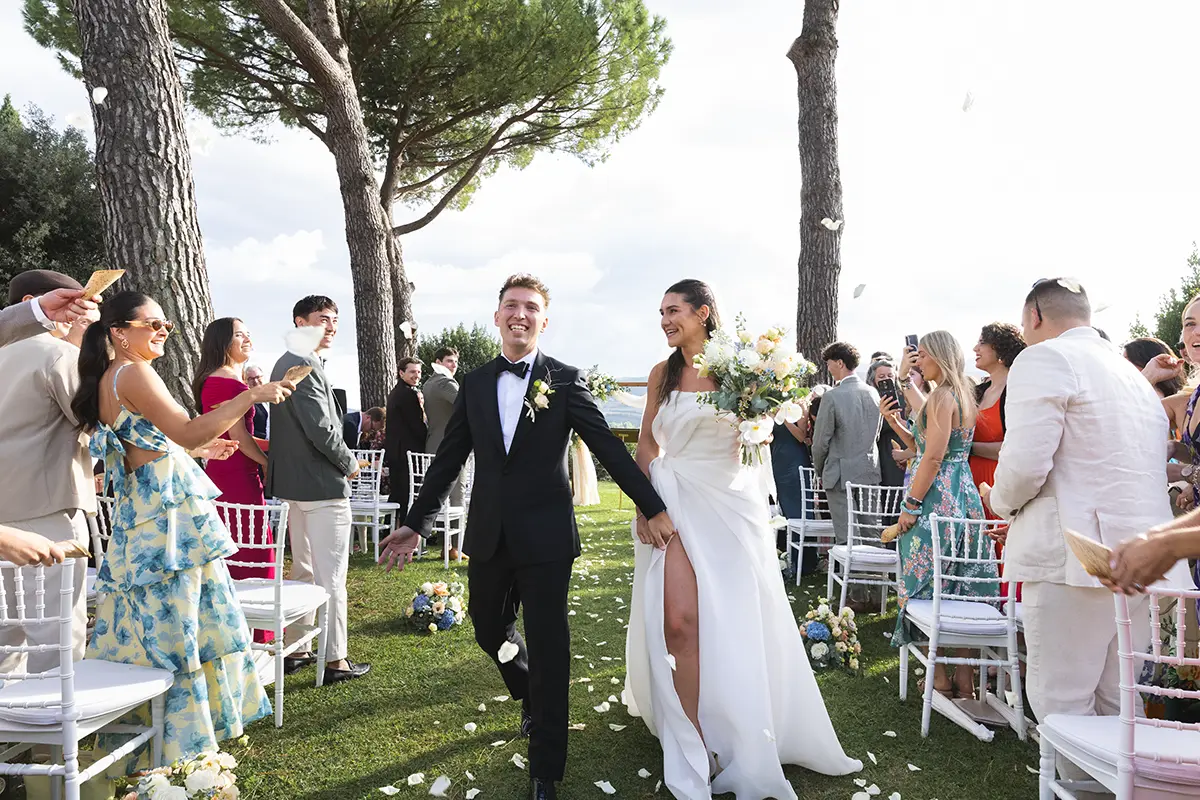 The newlyweds are surrounded by petals as they leave the ceremony in the garden of the Monastero Santa Margherita