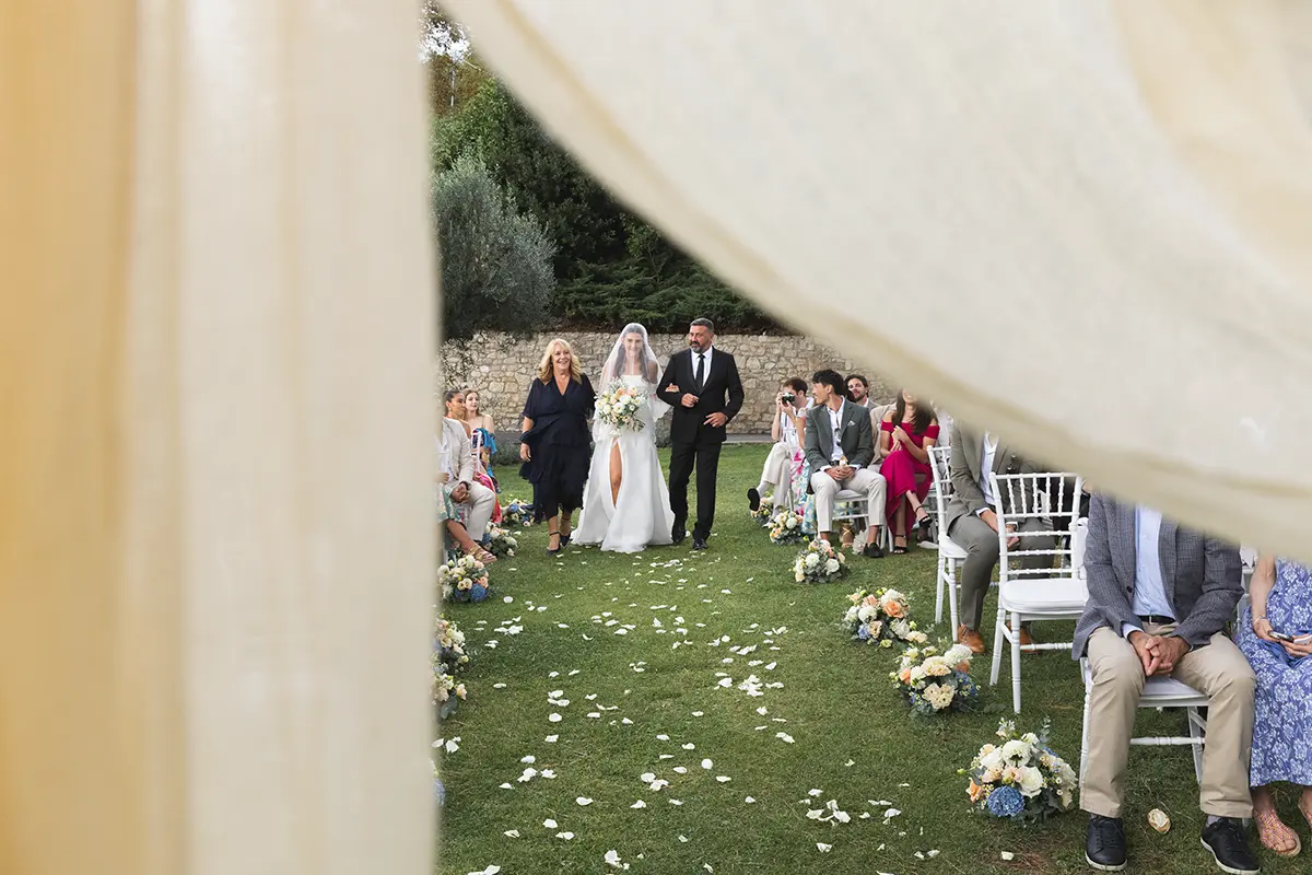 The bride is accompanied to the ceremony by her parents