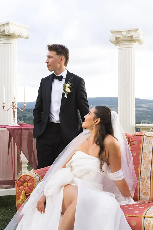 The bride sitting on a sofa looks at the groom