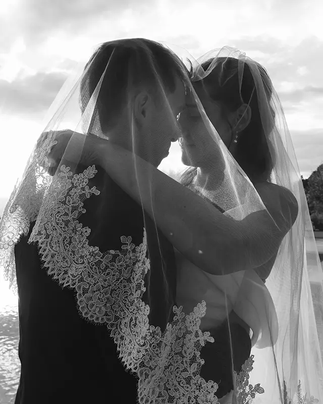 The newlyweds embrace under the wedding veil