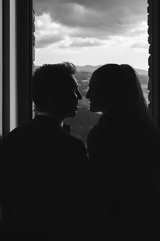Newlyweds look at each other in front of an Umbrian landscape