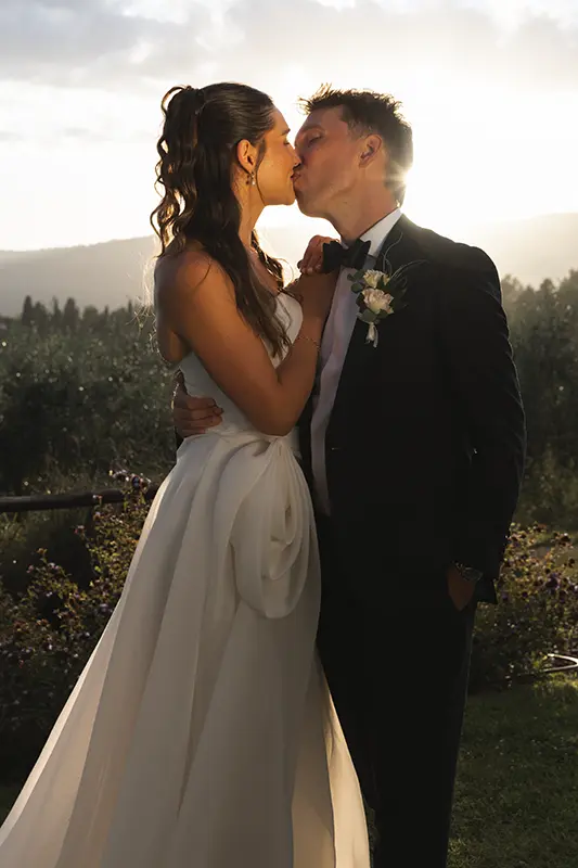 Newlyweds kiss at sunset in the garden of the Santa Margherita Monastery