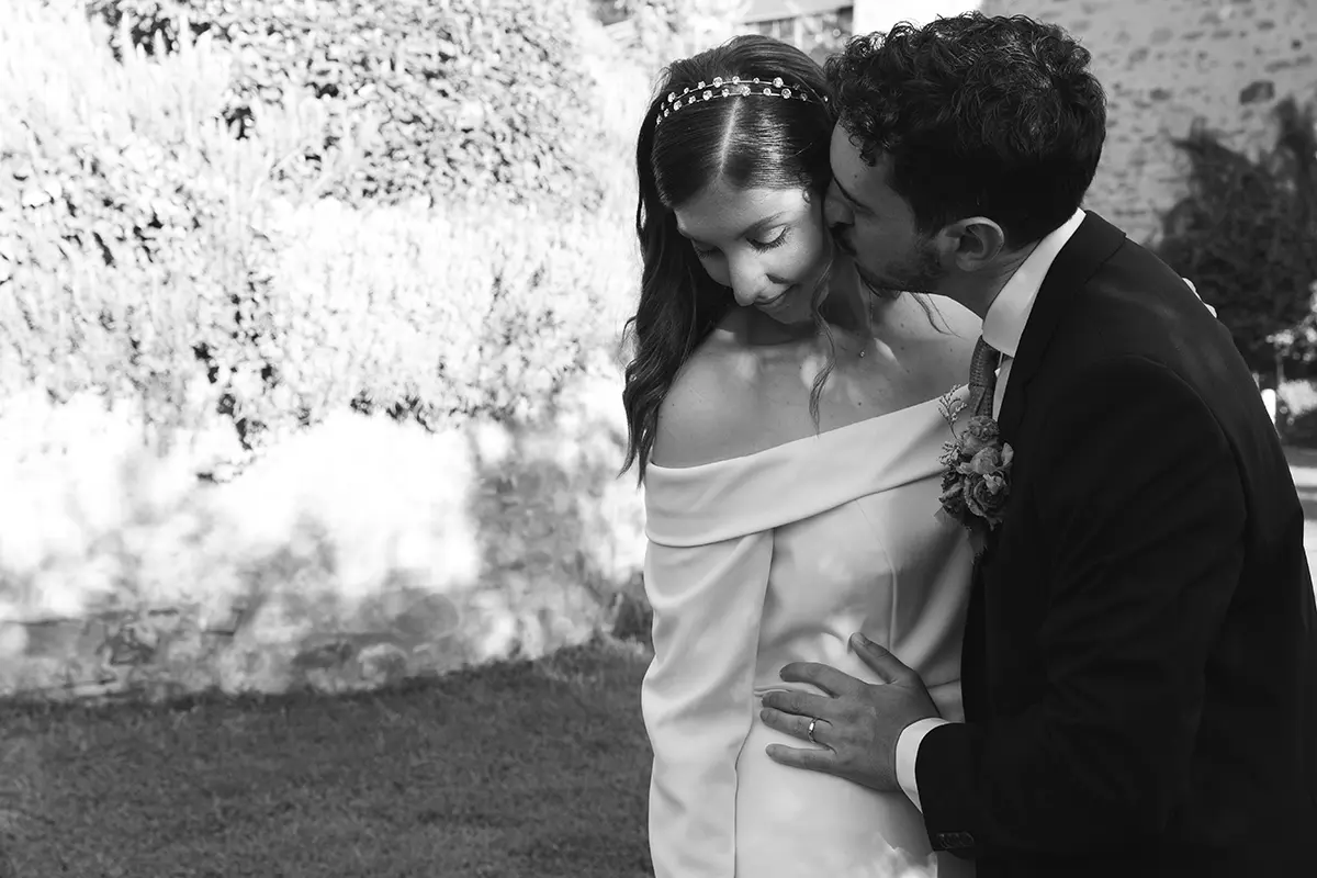 Groom kisses his bride on the cheek