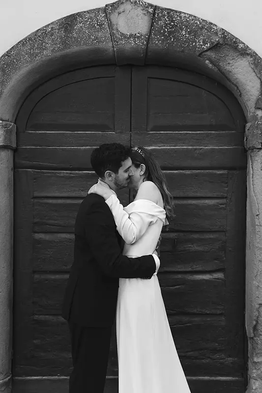 Newlyweds embrace in front of an old wooden door