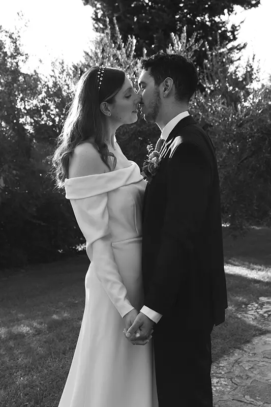 Newlyweds kiss while holding hands