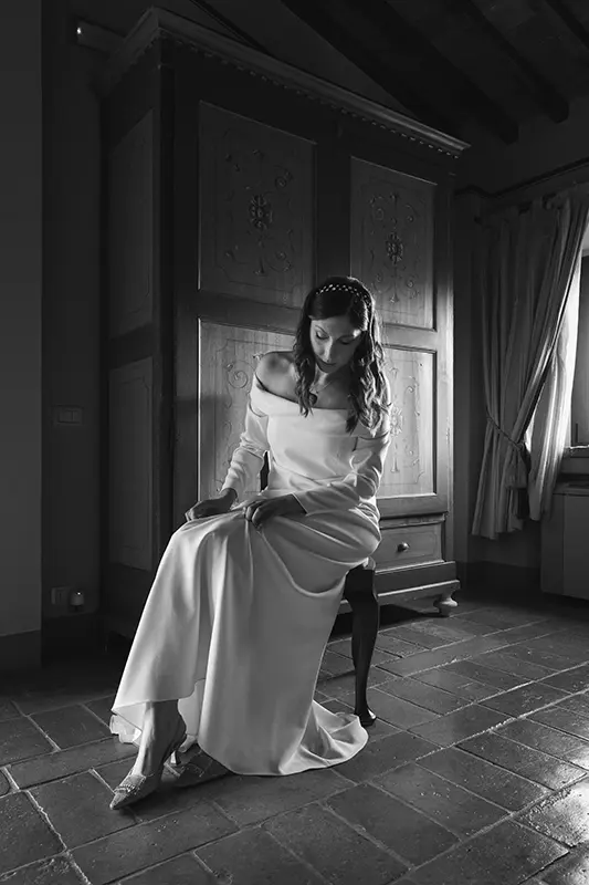 Sitting bride putting on her shoes